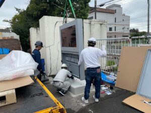 工場にデジタルサイネージを搬入する作業員
