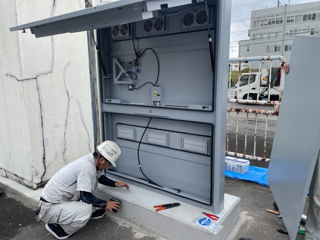 工場でデジタルサイネージを設置作業する作業員